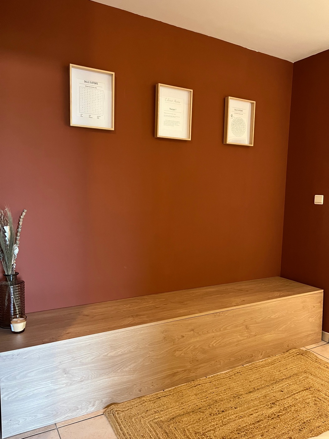 La salle d'attente du Cabinet Hestia, mur terracotta et banc en bois